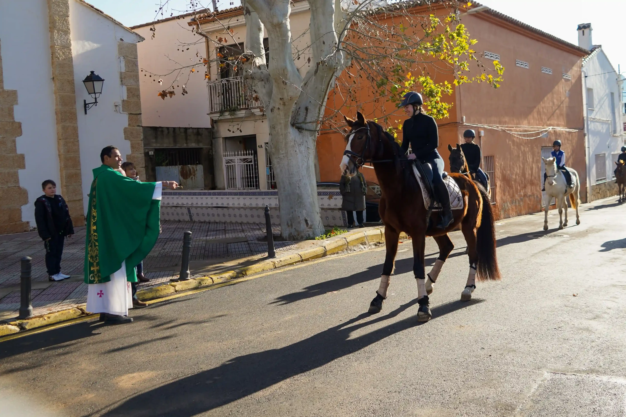 Caballo castaño montado por una amazona en el momento de la bendición en Sant Antoni 2025.