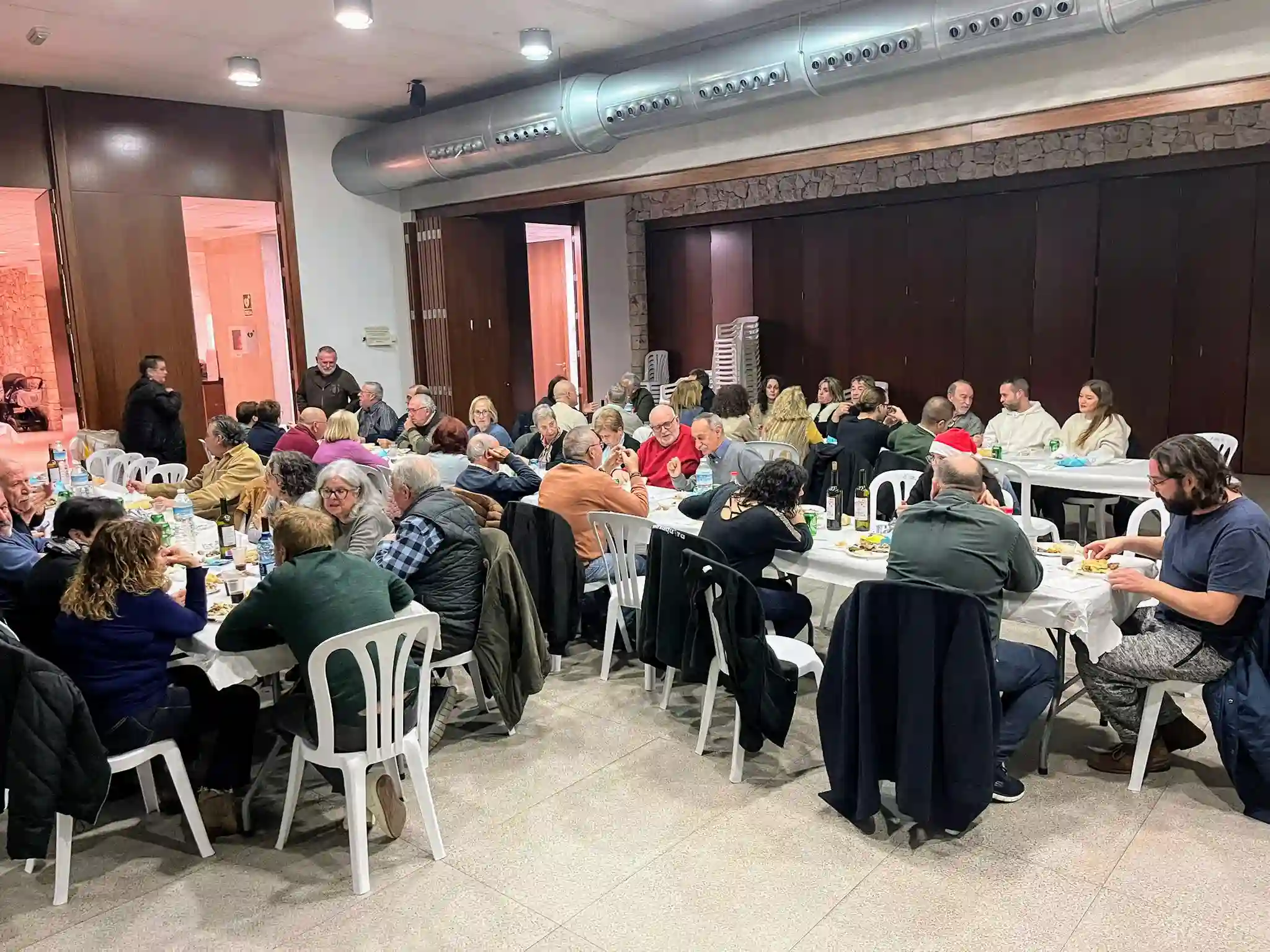 Larga mesa con numerosos vecinos compartiendo cena en el Sopar del Pobre organizado en Marxuquera