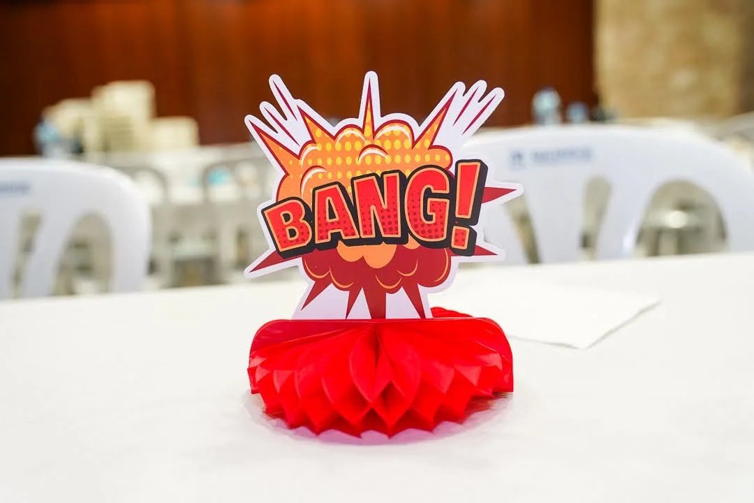 Detalle decorativo de centro de mesa con cartel “BANG!” durante la cena de Carnestoltes en Marxuquera 2025