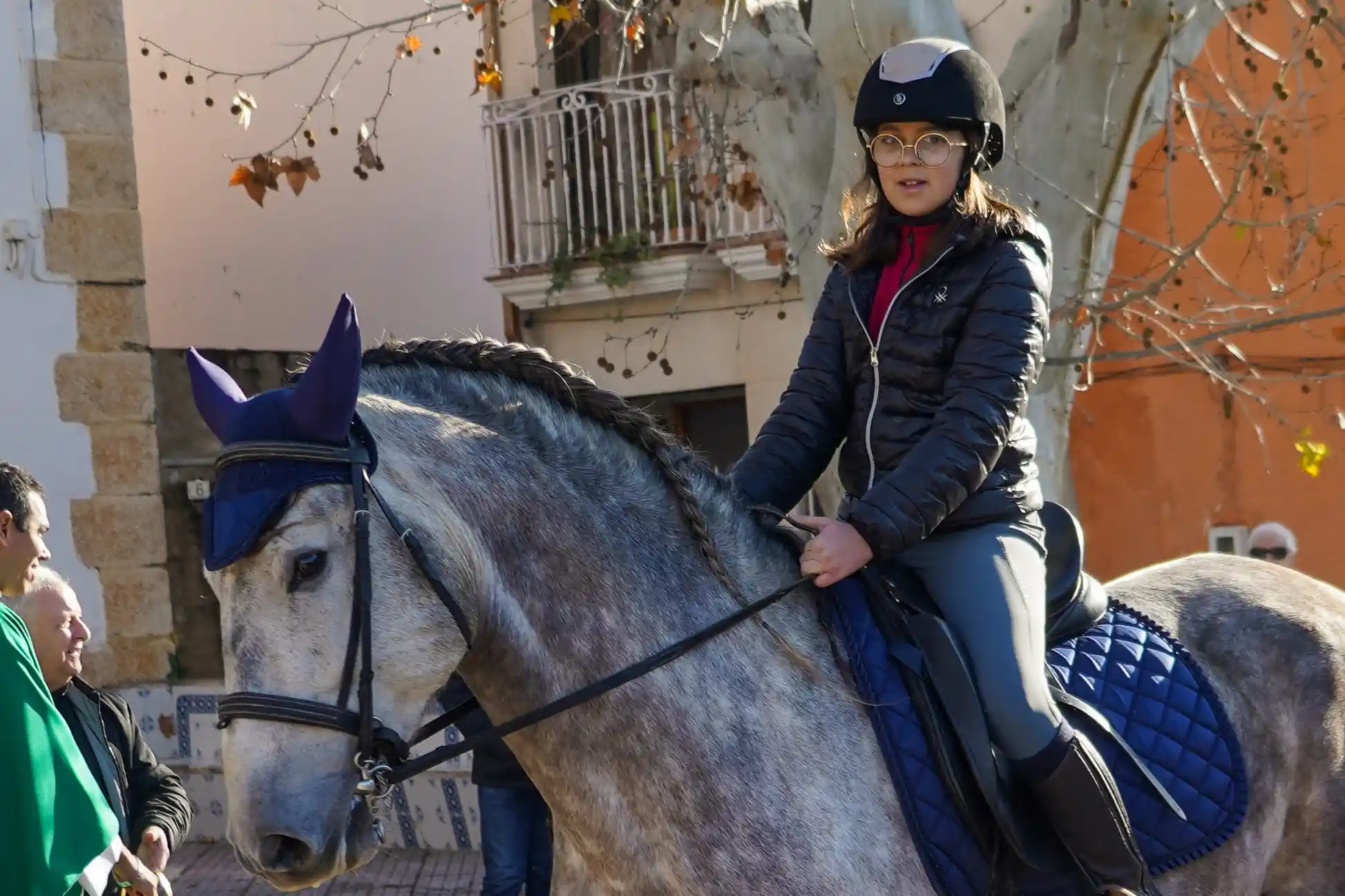 Chica montando un caballo tordo durante la bendición de animales en Sant Antoni 2025 en Marxuquera.
