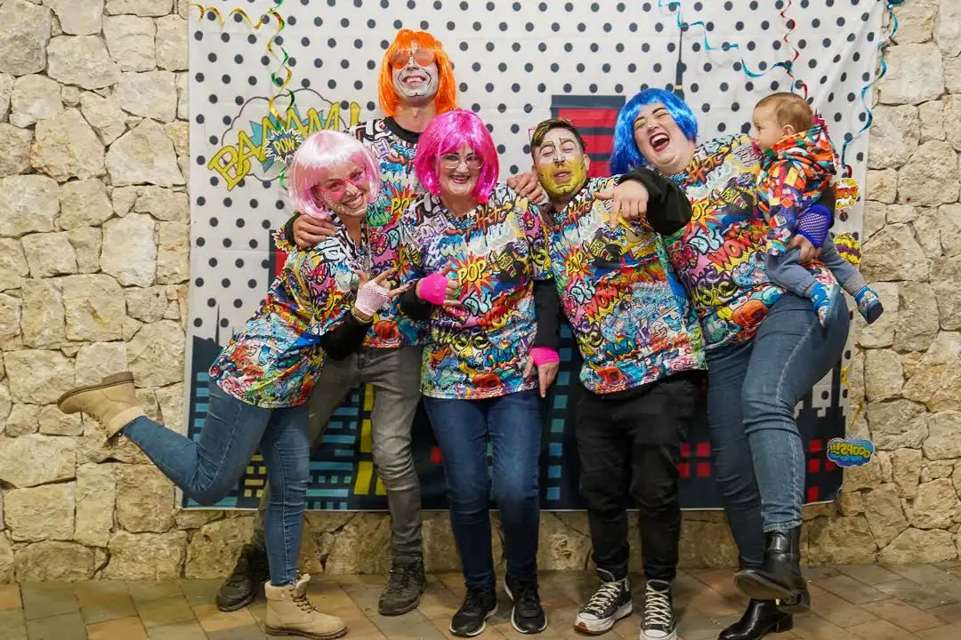 Miembros de la comisión disfrazados con pelucas llamativas durante el Carnaval 2025 en Marxuquera