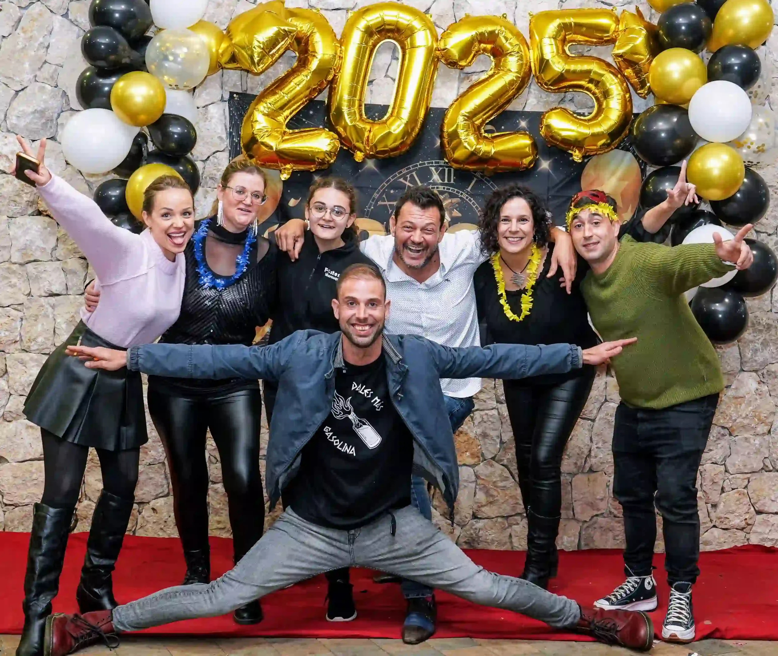 Foto de grupo de la comisión de Marxuquera celebrando el año nuevo con entusiasmo y alegría bajo el 2025