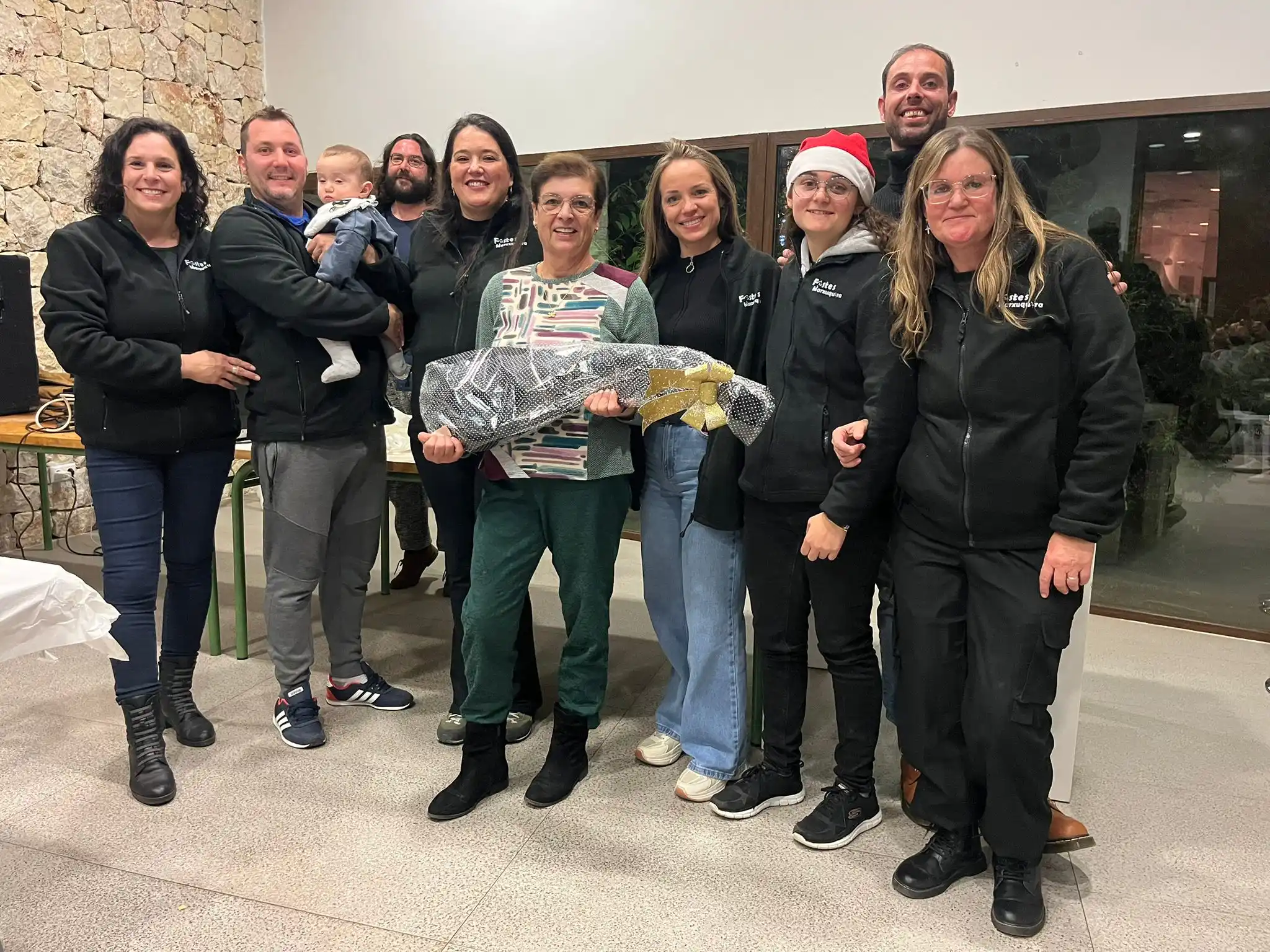 Miembros de la comisión de festes de Marxuquera entregando el jamón de la rifa durante el Sopar del Pobre 2024