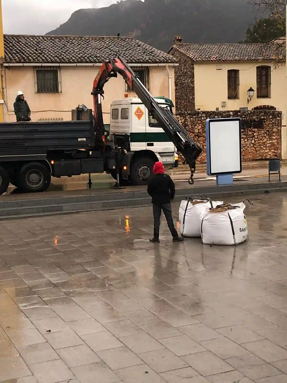 Camión descargando sacos de arena para preparar la base de la hoguera en Sant Antoni 2025.