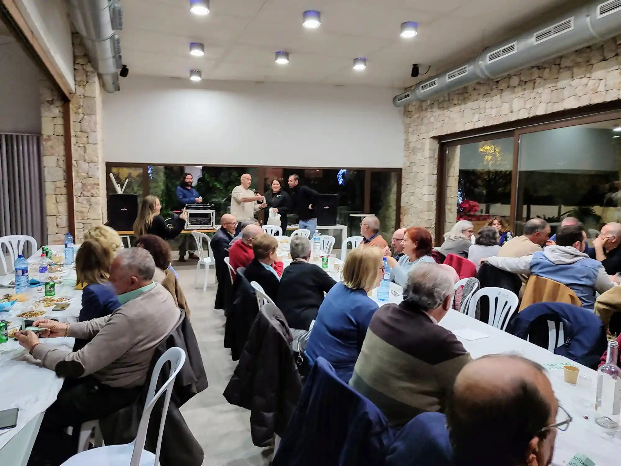 Público atento al discurso y animación al final del Sopar del Pobre en el Centro Social de Marxuquera