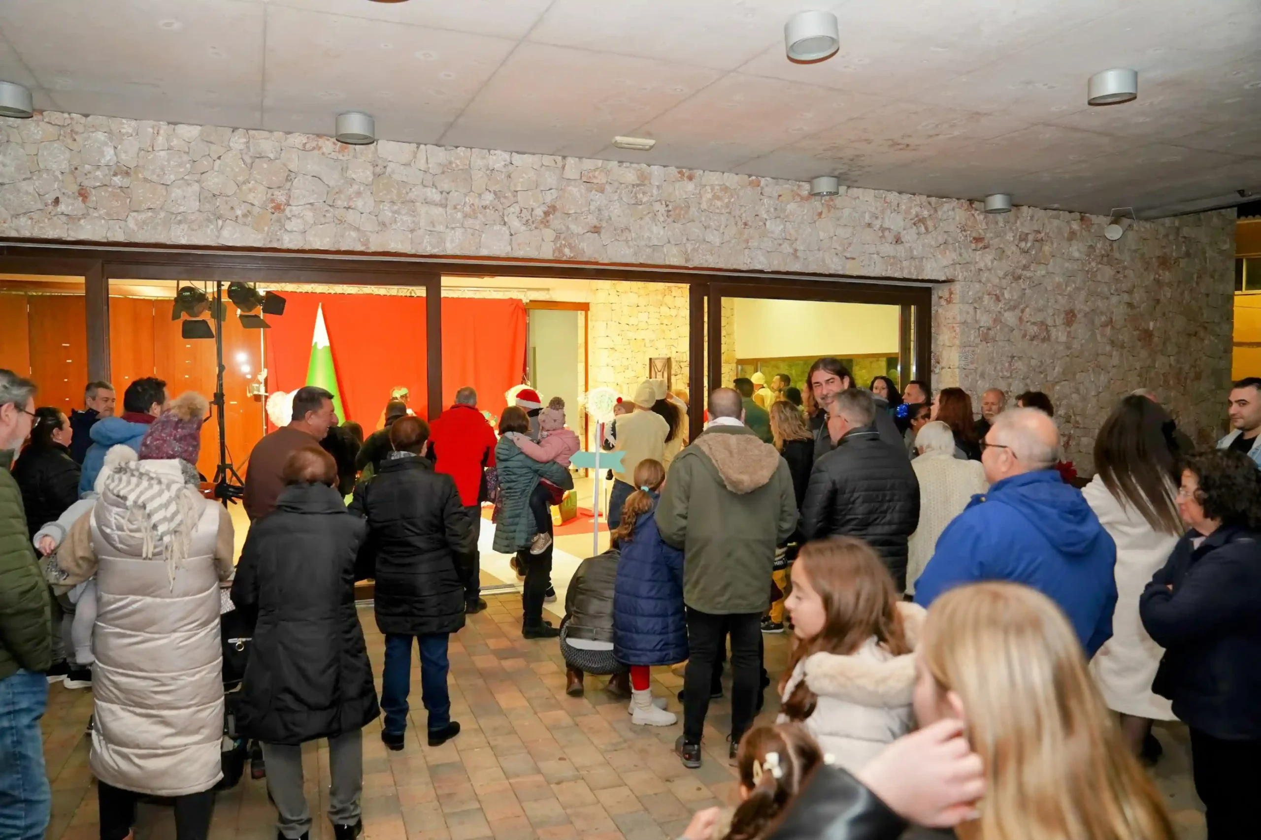 Vecinos y familias de Marxuquera esperando en fila para ver a Papá Noel en el Centre Social durante la Navidad 2024
