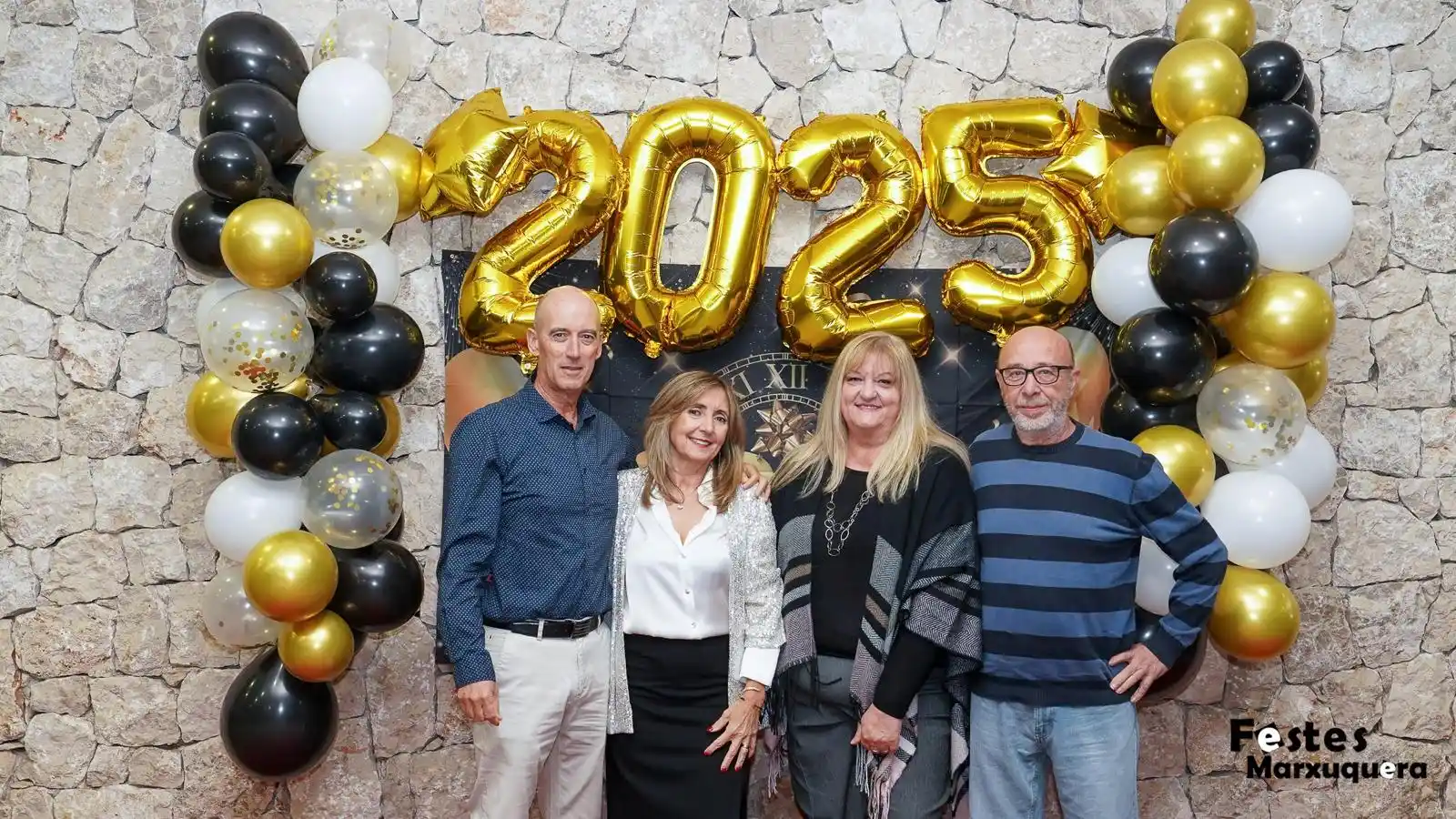 Dos parejas posan felices junto a la decoración dorada de 2025 durante la cena y cotillón de fin de año en el Centre Social