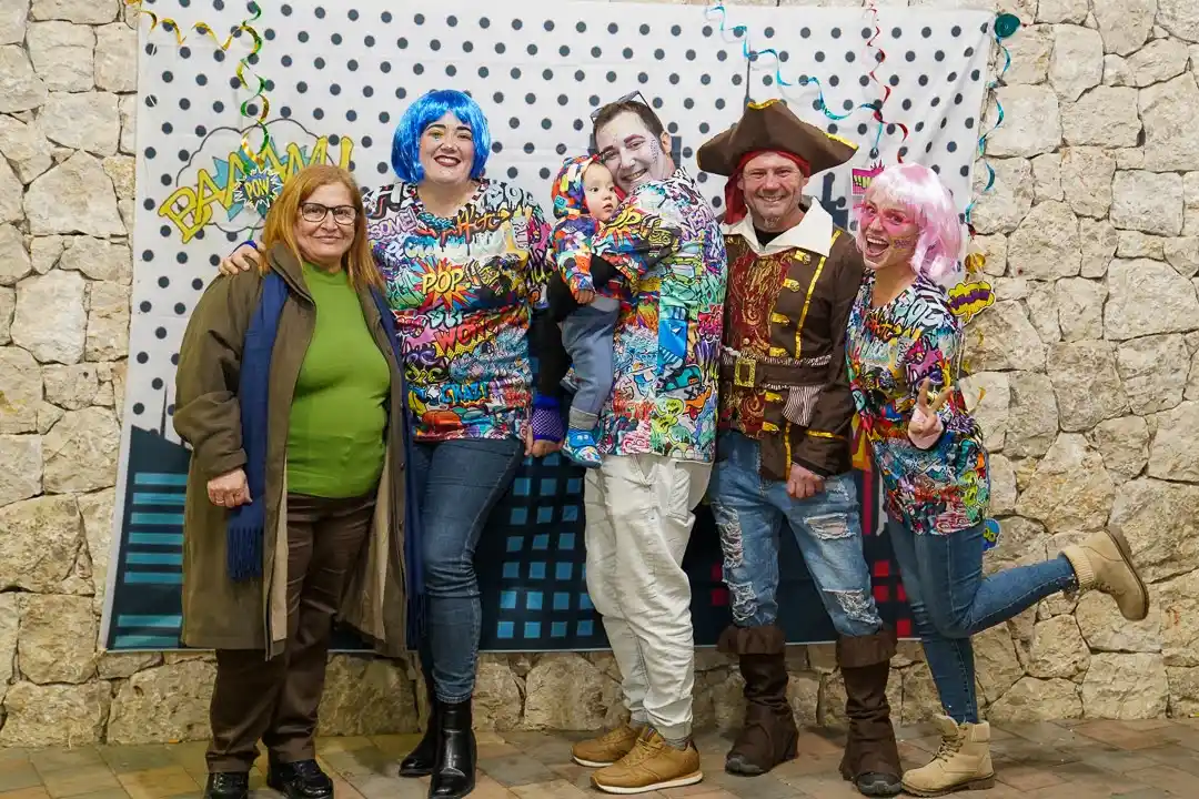 Familia disfrazada con un bebé posando en el fotocall del Carnestoltes 2025 en Marxuquera