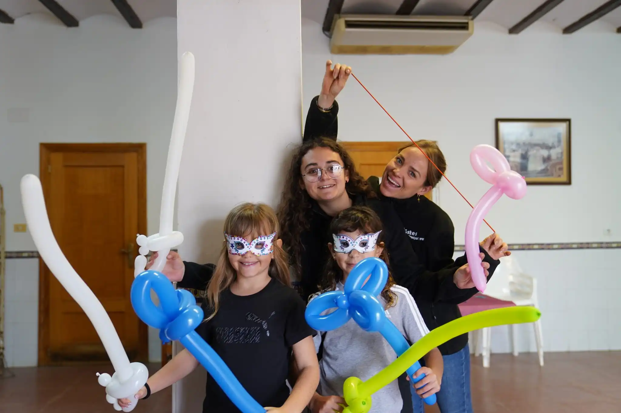 Niñas participando en taller de globoflexia con figuras de globos en el Carnaval 2025 en Marxuquera