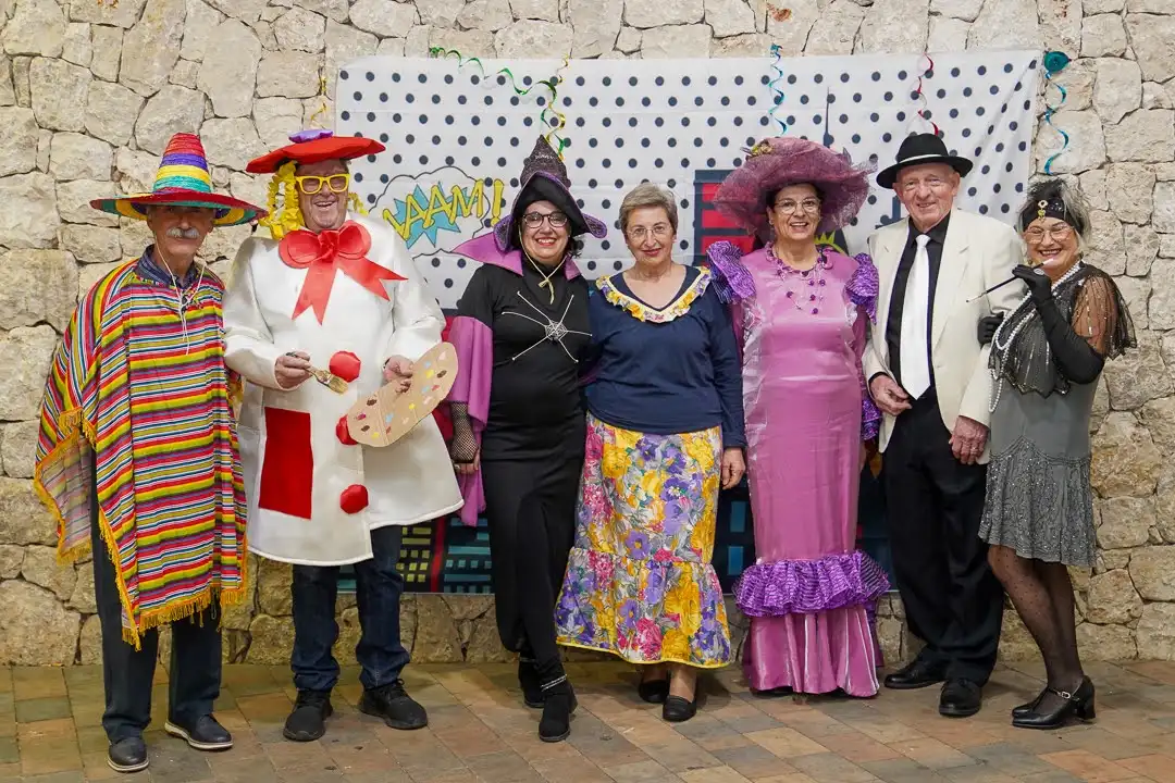 Adultos con disfraces originales posando en el fotocall de los Carnavales 2025 en Marxuquera