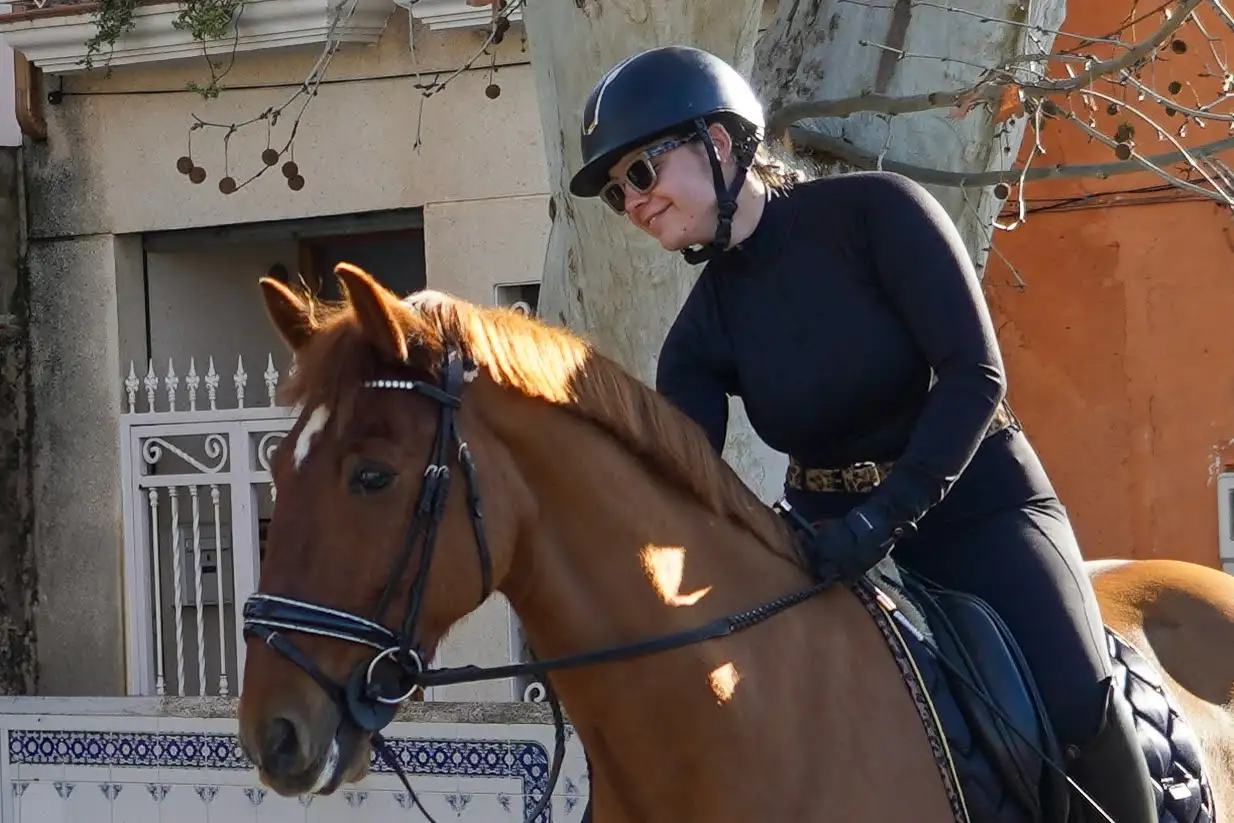 Jinete sonriente acariciando a su caballo durante la bendición de animales en Sant Antoni 2025 en Marxuquera.