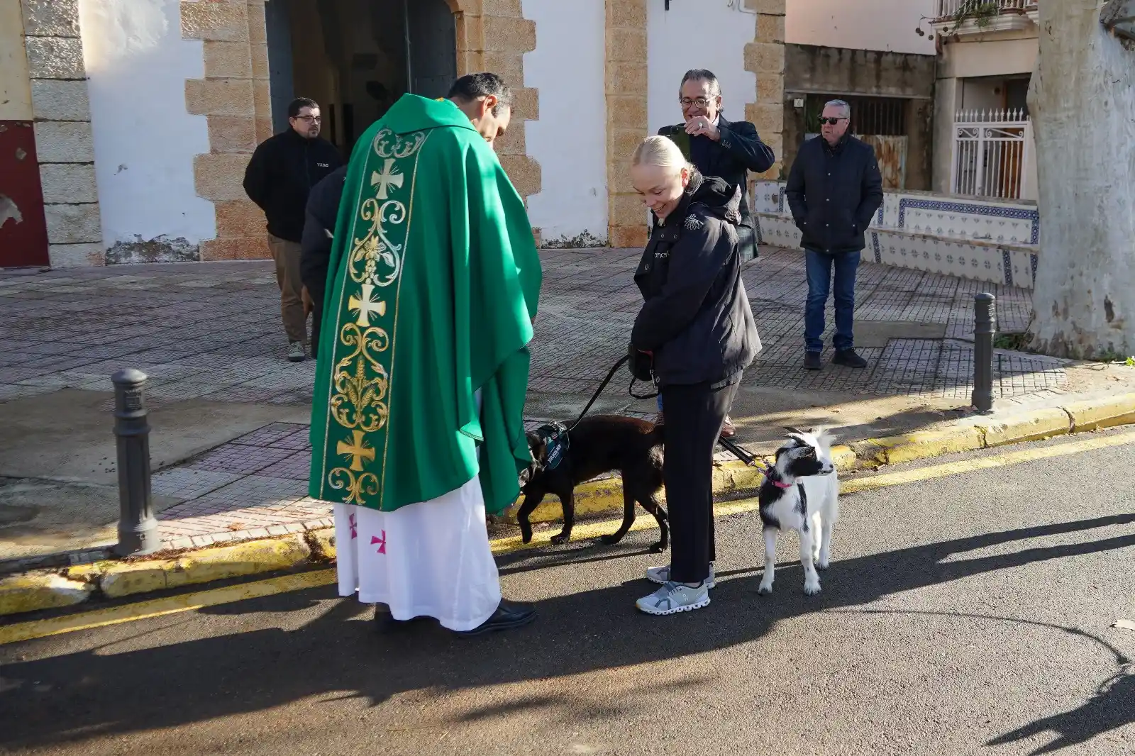 Mujer acompañada de un perro y una cabrita recibiendo la bendición frente a la iglesia en Sant Antoni 2025 en Marxuquera.