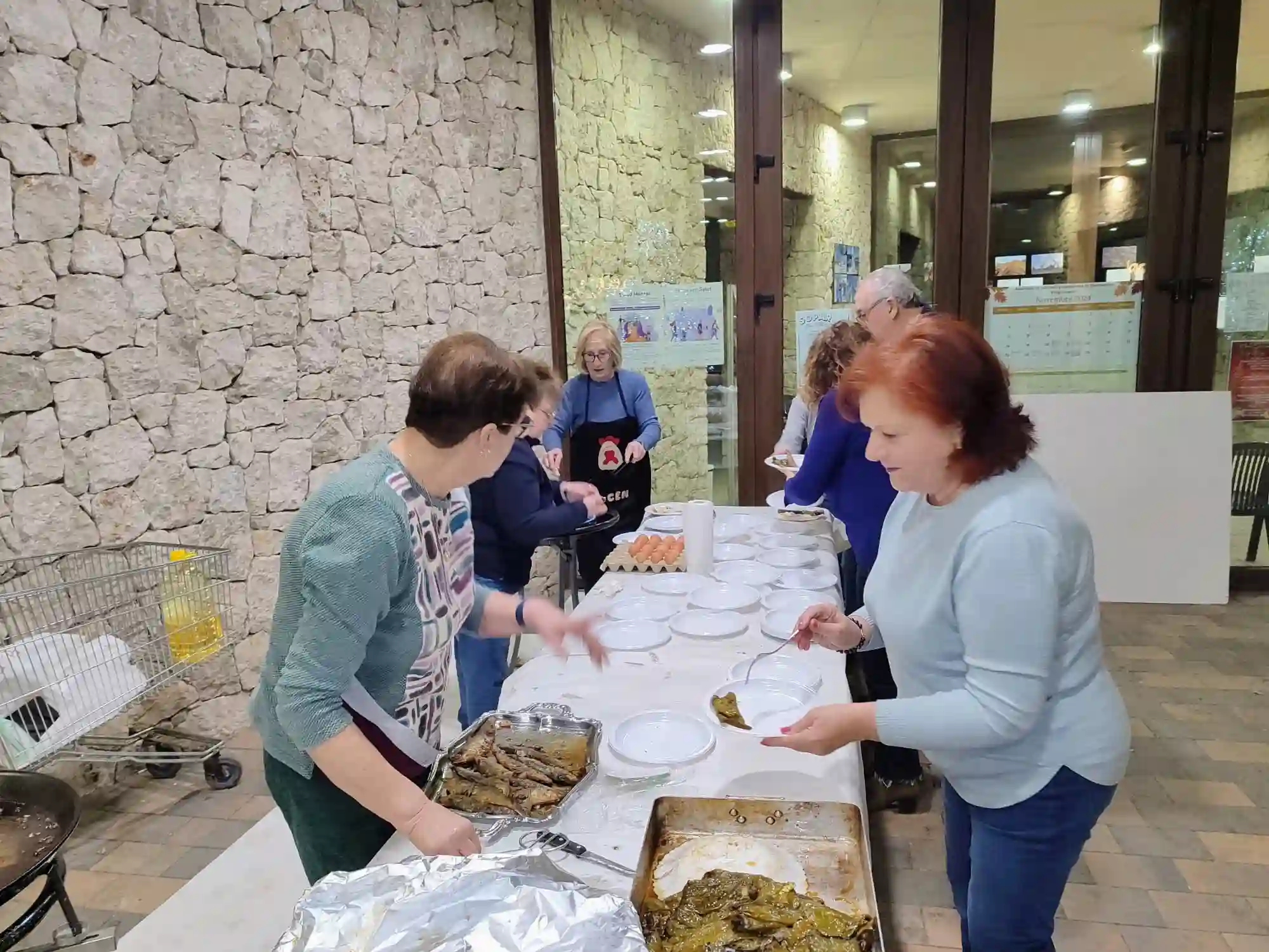 Preparación de platos con sardinas y pimientos por parte de las vecinas en el Sopar del Pobre de Marxuquera