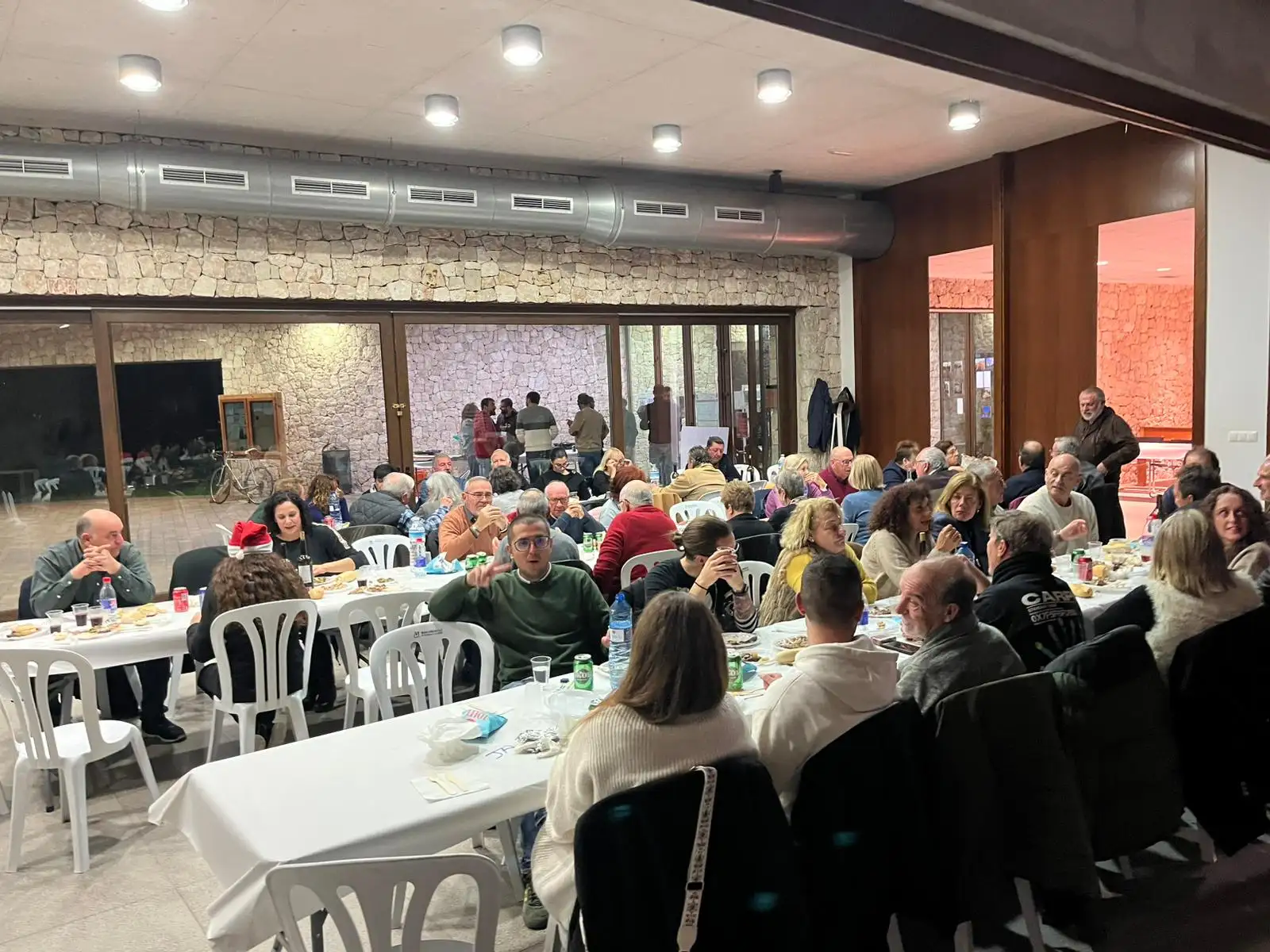 Vista general de los vecinos y vecinas de Marxuquera cenando juntos en el Sopar del Pobre 2024 en el Centre Social
