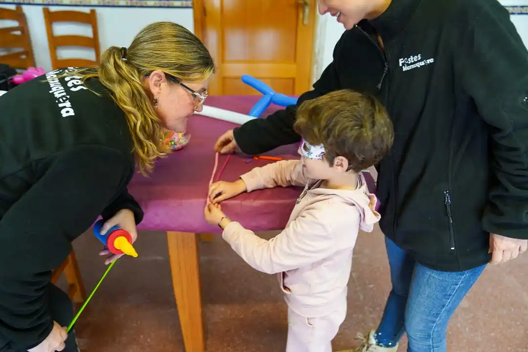 Niña decorando su globo en el taller infantil de los Carnavales 2025 en Marxuquera